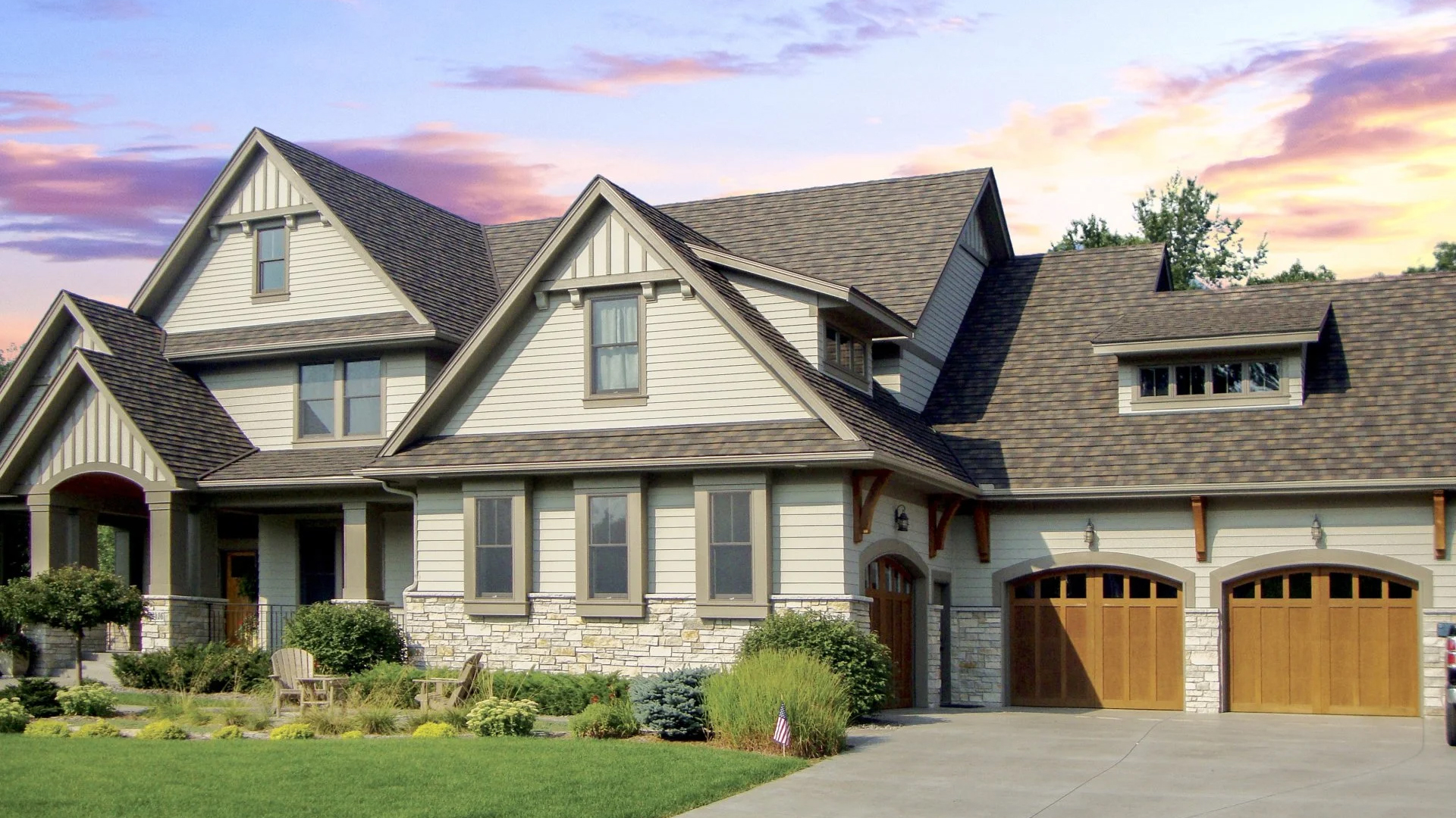 A DECRA Shingle XD roof (DECRA product photo) A two-story house with gables and dormers, roofed with DECRA Shingle XD stone-coated steel panels
