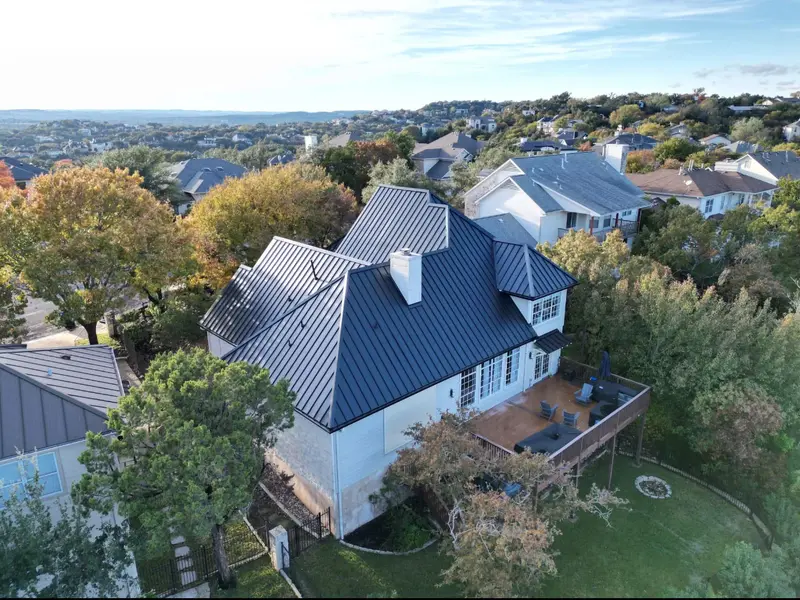 Bronze standing seam metal roof on a two-story hilltop home