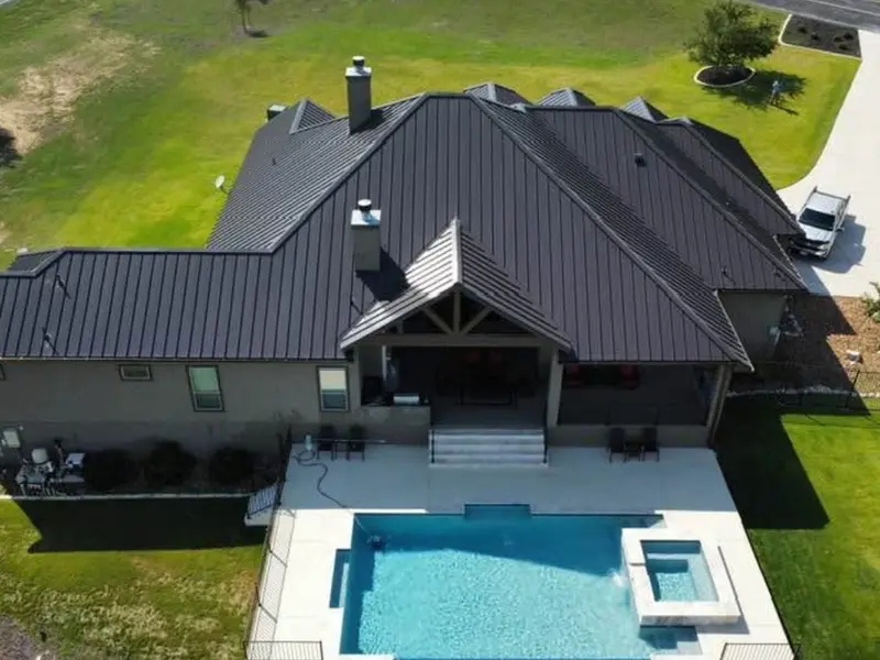 Bronze standing seam metal roof on a single-story home with a pool