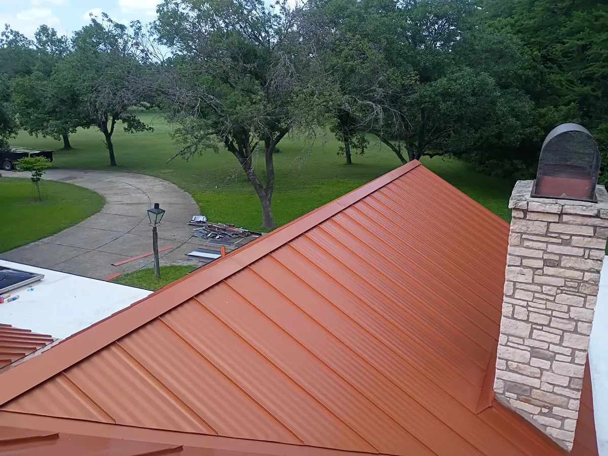 Copper-tone standing seam metal roof installed by RISE Roofing