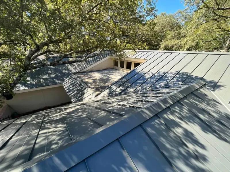 Gray standing seam metal roof on a mid-century home